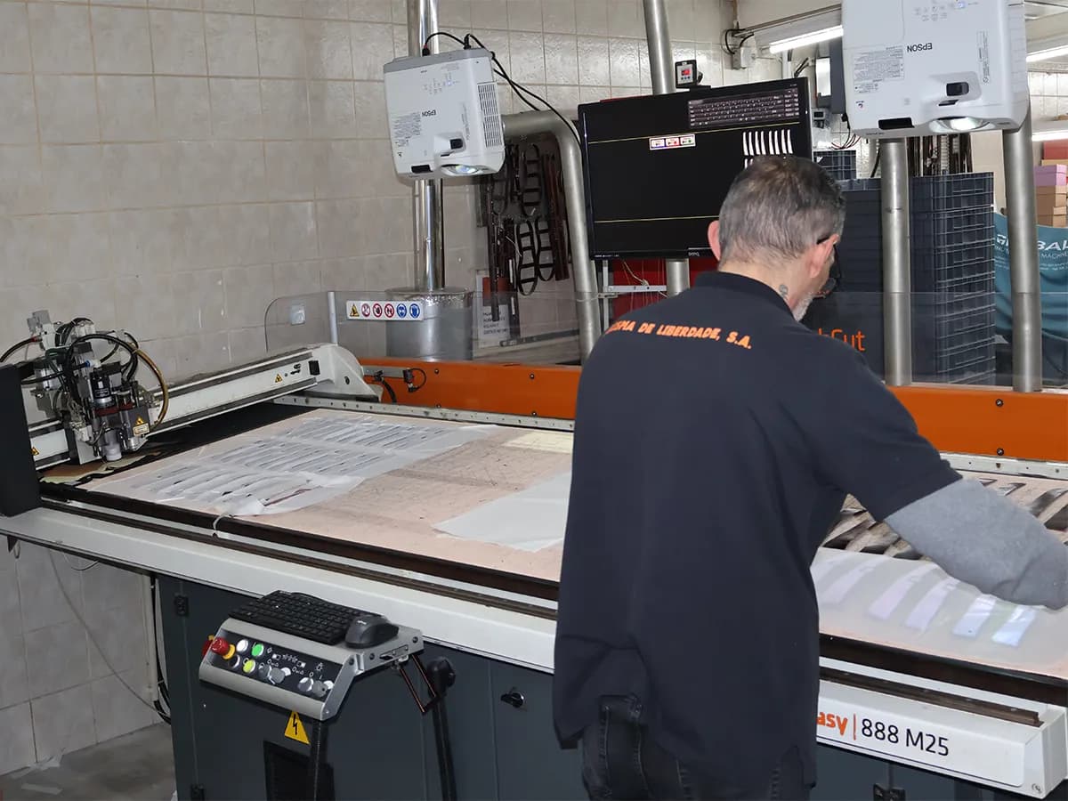 Trabalhador a operar máquina de corte automatizada